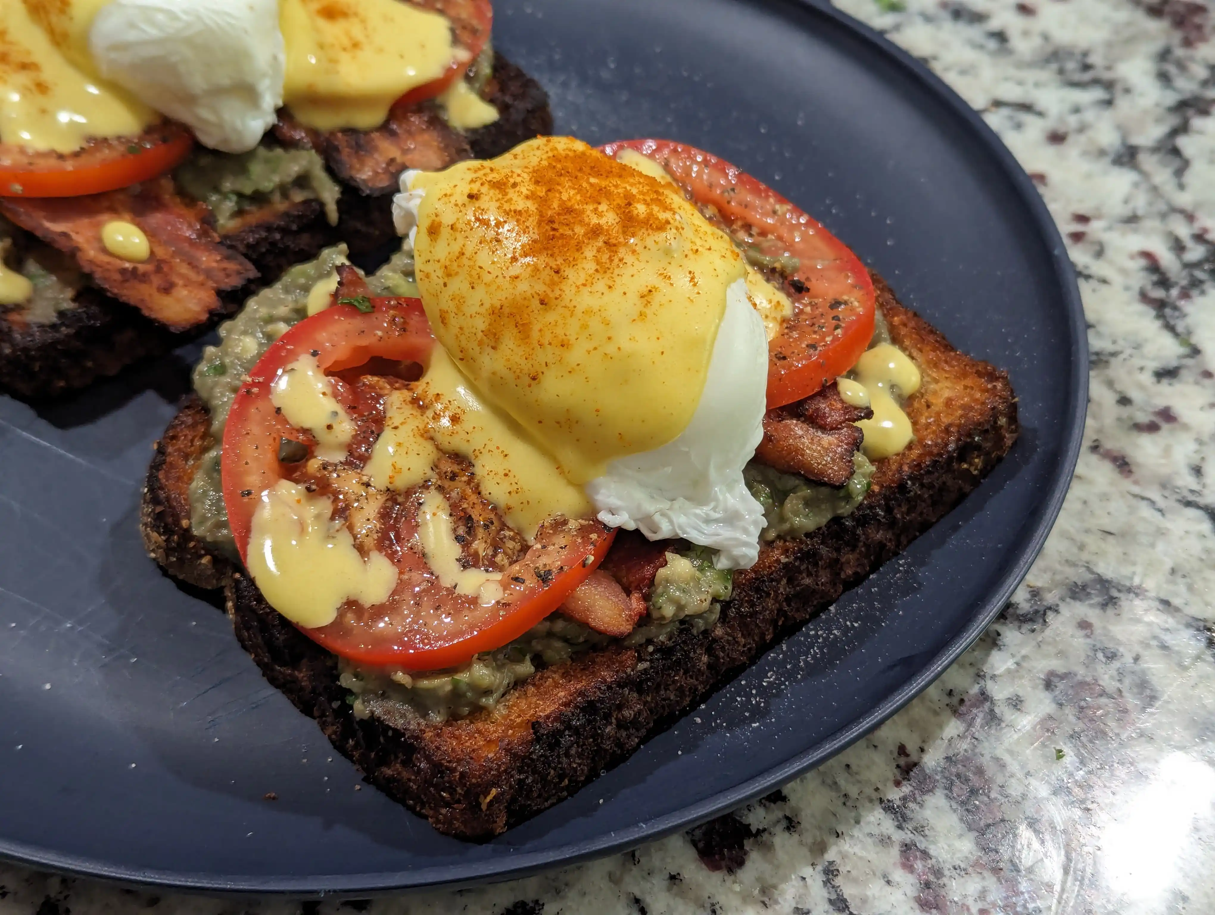 Avocado toast topped with eggs and hollandaise sauce