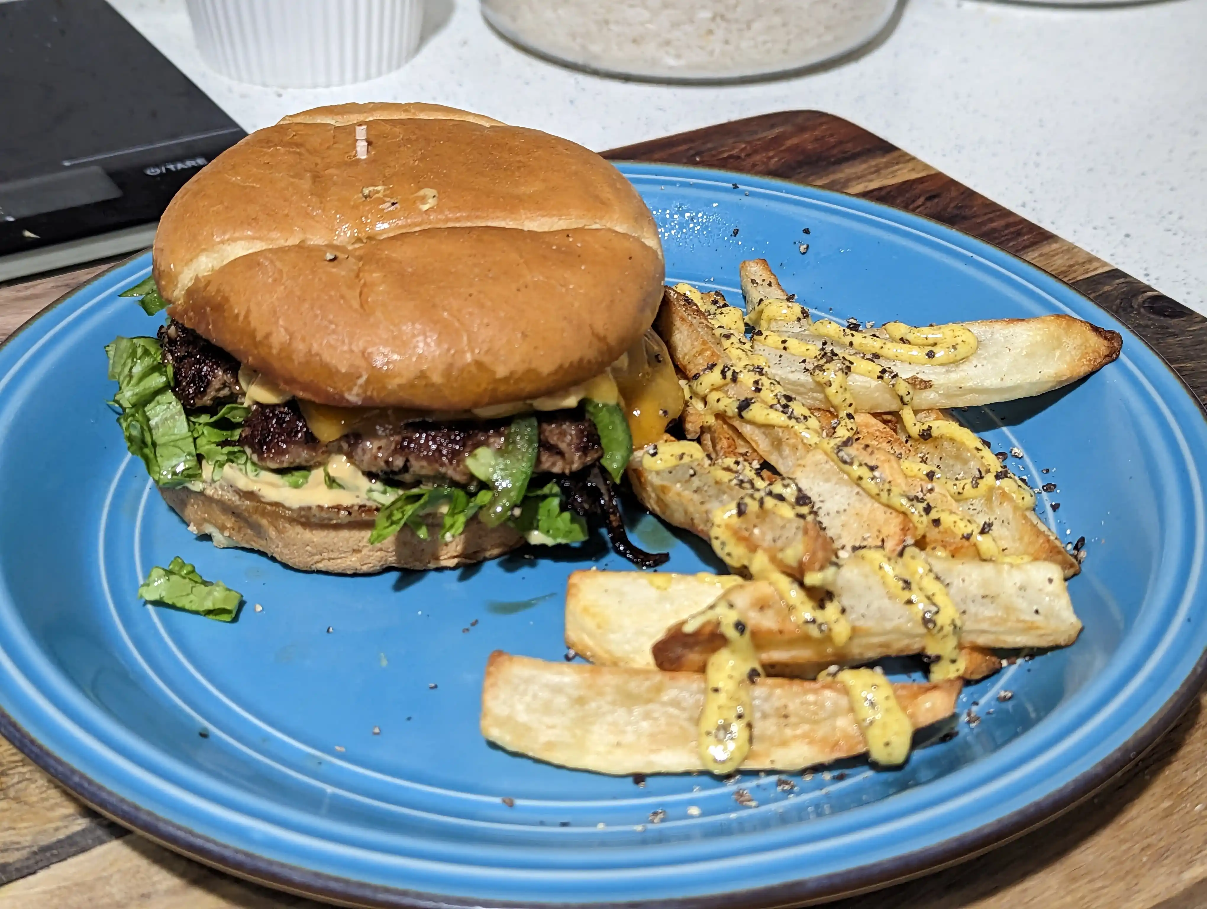 Burger with side of fries topped with curry aioli